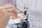 Seamstress woman repair cleans sewing machine, replacement of needle and thread. Concept tailor workplace