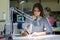 A seamstress works behind a sewing machine in a sewing shop at her workplace