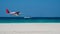 Seaplane fly low above sea level by the sandy beach