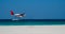 Seaplane fly low above sea level by the sandy beach