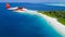 Seaplane flying above exotic iceland in Maldives.