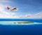 Seaplane flying above small tropical island on Maldives