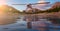 Seaplane flying over the glacier water. Colorful Sunset Sky.