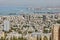 Seaport in the city of Haifa, panorama of the port and city buildings against the background of a blue sky with clouds