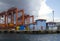 Seaport crane and containers with cloudly dark sky