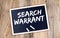 SEARCH WARRANT text on chalkboard on the wooden background