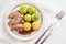 Seared duck breast fillet with duchess potatoes and brussels sprout, a festive dinner on a white table, high angle view from above