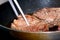 Seared fillets of beef steak cooking in a frying pan.