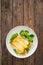 Seared halibut fillet, sliced lemon and boiled broccoli on wooden table