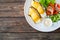 Seared halibut and fresh vegetables on wooden table