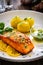 Seared salmon steak with boiled potatoes and lemon served on wooden table