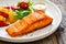 Seared salmon steak with grilled bell pepper and mayonnaise on wooden table