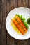 Seared salmon steak with lettuce and lemon on wooden table