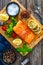 Seared salmon steak with lettuce, tomatoes and lemon on wooden table