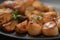 Seared scallops fith roasted potatoes on black plate closeup