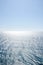 Seascape background of clear sky and vivid blue sea with sunlight reflection on surface