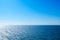 Seascape background of clear sky and vivid blue sea with sunlight reflection on surface