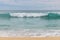 Seascape background. Sandy beach, milky foam waves, blue ocean. Scenic waterscape. Horizon line. Cloudy sky. Nature and