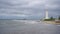 Seascape with beautiful white lighthouse against stormy sk and sea