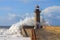 Seascape with big wave crashes at the lighthouse. Maritime landscape. Porto landmark, Portugal. Storm on the stone jetty with very