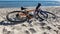 Seascape. The bike lies on the sand. Azure water, waves foaming on the shore. Sports check-in. Selective focus