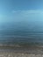 Seascape in blue tones, the horizon line is located in the center of the image, there is free space for text, copy space, vertical