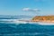 Seascape in blue and turquoise colors. Pacific ocean, cliffs, and silhouette of Morro Rock. View from Montana del Oro state park