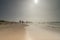 Seascape with blurred people walking in the background. Silhouette of people on the beach and in the sea, people fishing