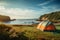 Seascape campsite Tent and camping equipment on vibrant green grass