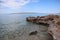 Seascape clear sea, rocky coast and cairn on a sunny summer day