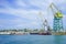 Seascape with the coastline of the port and large floating cranes