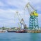 Seascape with the coastline of the port and large floating cranes