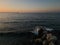 Seascape with crushing waves and old deserted industrial jetty in the distance at sunset at Karavostasi area near Lefka, Cyprus