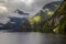 Seascape in Doubtful Sound Fiord, New Zealand, green costline and reflection in a wather, cloudy weather