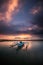 Seascape. Fisherman boat. Traditional Balinese boat jukung. Fishing boat at the beach during sunrise. Water reflection. Cloudy sky