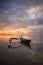 Seascape. Fisherman boat. Traditional Balinese boat jukung. Fishing boat at the beach during sunrise. Water reflection. Cloudy sky