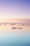 Seascape with floating glaciers at dawn. Serene winter arctic landscape. Icebergs on calm sea horizon at sunset in