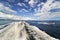 Seascape. A foamy white trail from a boat on the blue water. Islands are visible on the horizon