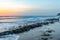 Seascape horizon with rocks in the water and ocean waves at sunrise on Cabarete beach, Dominican Republic