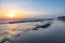 Seascape horizon with rocks in the water and ocean waves at sunrise on Cabarete beach, Dominican Republic