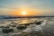 Seascape horizon with rocks in the water and ocean waves at sunrise on Cabarete beach, Dominican Republic