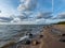 Seascape image of the sea with cloudy sky before sunset,  stones and  of light before sunset, beautiful sunny day and quiet sea.