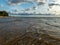 Seascape image of the sea with  stones and grass of light before sunset,  quiet sea