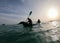 Seascape with kayakers at sunset. silhouette man in the kayak on the ocean in front of dramatic sundown