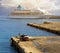 Seascape. A large white cruise ship stands in the tourist sea port at sunset, Rhodes, Greece. cars with fishermen in the