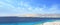 Seascape large wide panorama with desert mountains, bay with ships, sunny blue sky