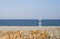 Seascape with lifeguard hut on calm sky background. Beach with lonely man