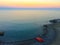 Seascape with a little red boat on the seashore