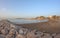 Seascape with Malaga and sunrise sunlight. Sandy beach of the Mediterranean Sea and walking stone pier in Playa de la Caleta,