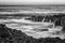 Seascape with motion blur and water flowing over the coral cliff.